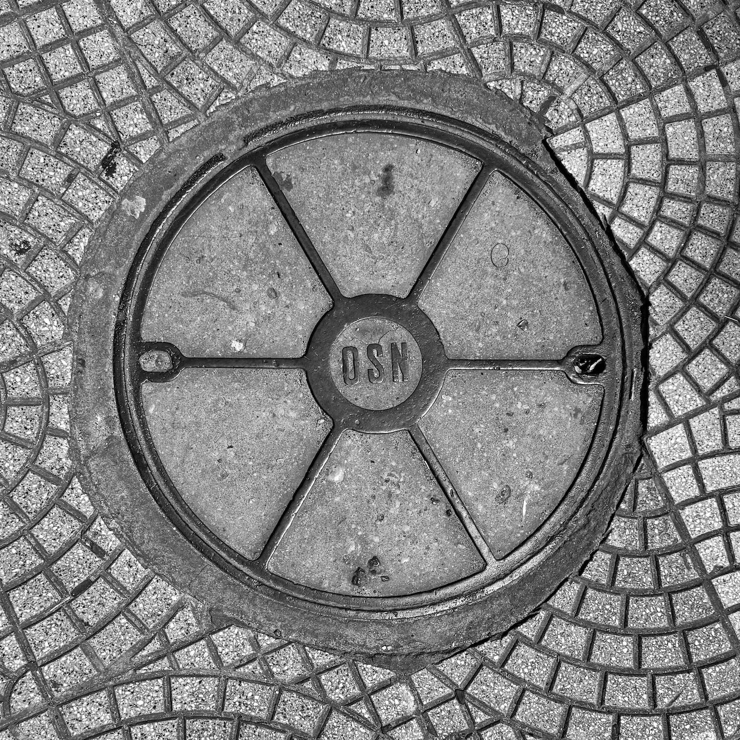 black and white image of a utility cover