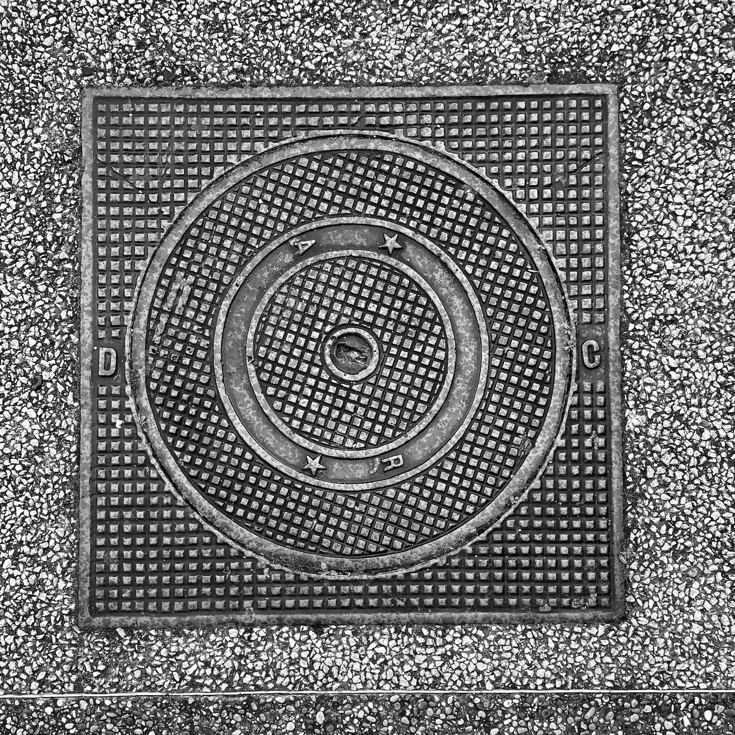 black and white image of a utility cover