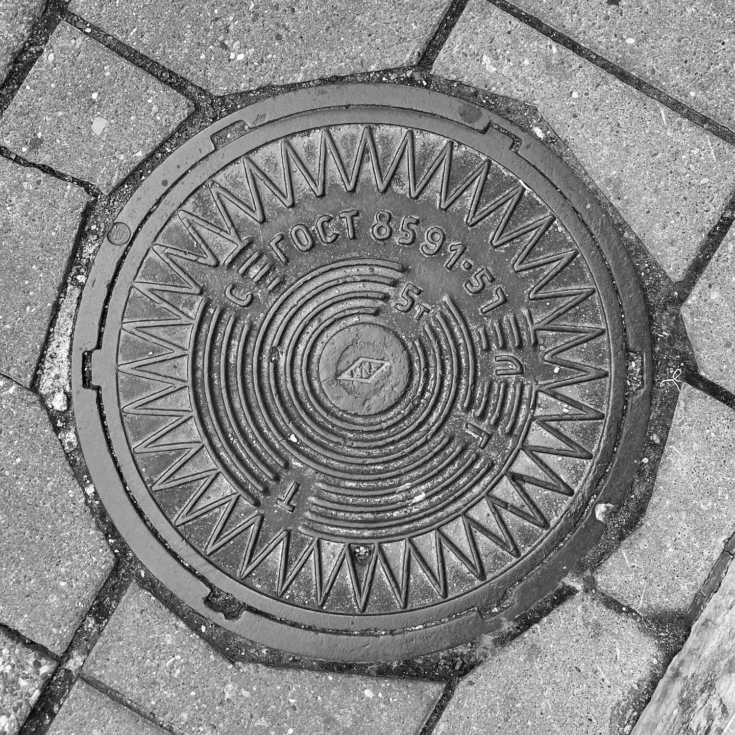 black and white image of a utility cover