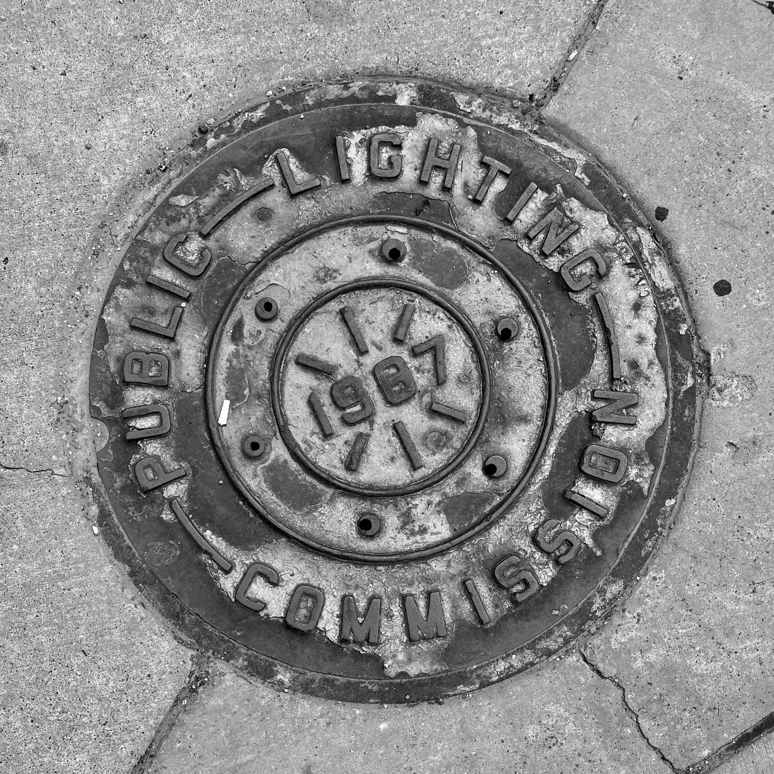 black and white image of a utility cover