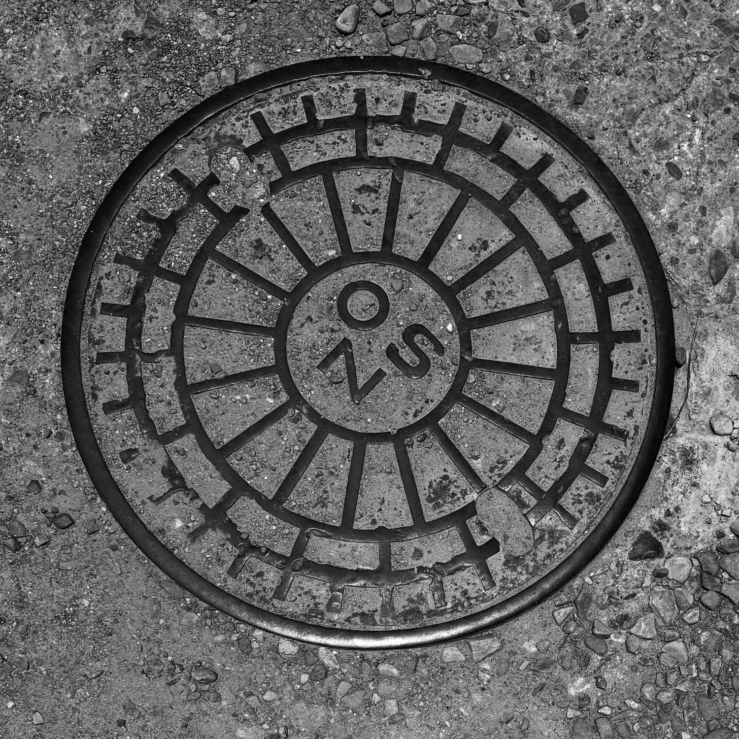 black and white image of a utility cover