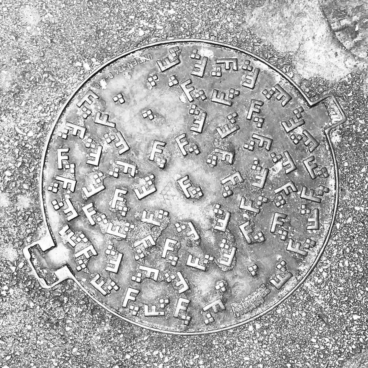 black and white image of a utility cover